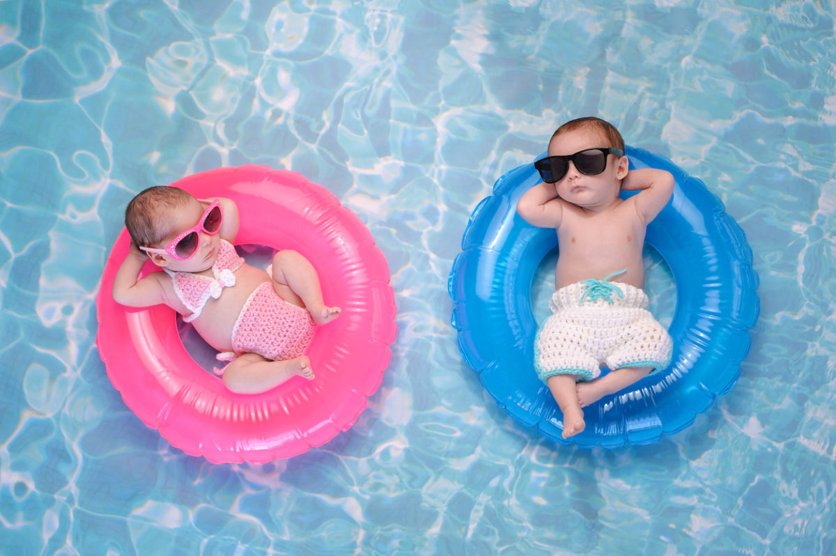 一对双胞胎小男孩和小女孩漂浮在游泳圈上