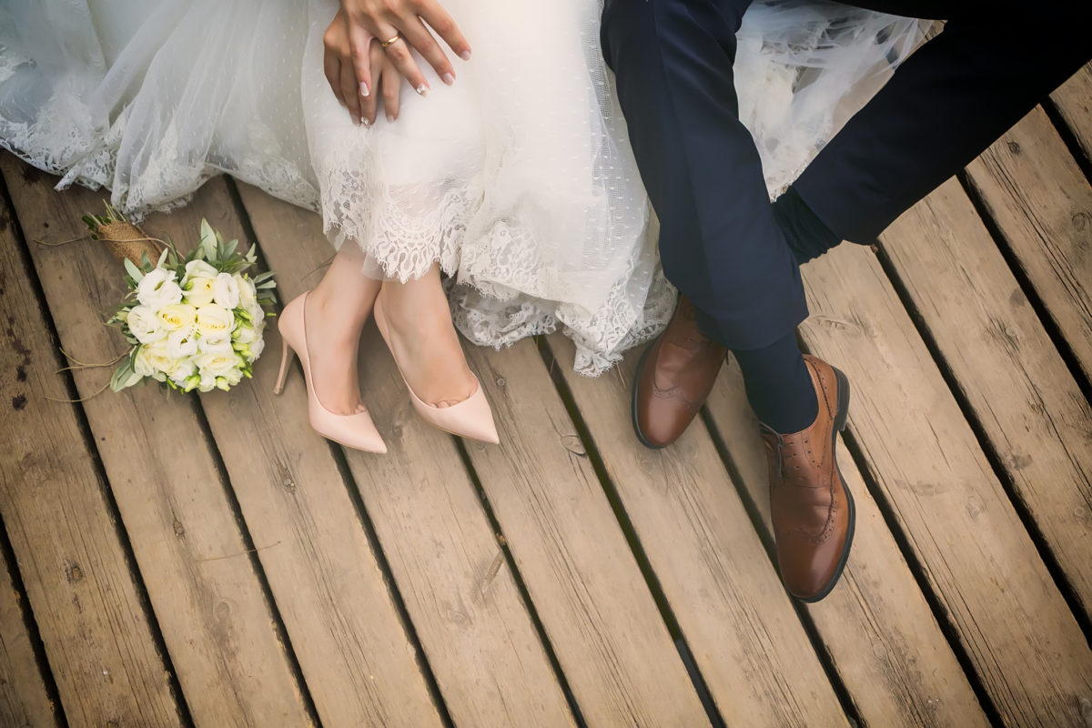 新郎新娘的脚，婚礼鞋(软焦点)。交叉处理的图像为新娘和新郎的复古外观英尺，婚礼鞋(软焦点)。交叉处理的图像，复古外观