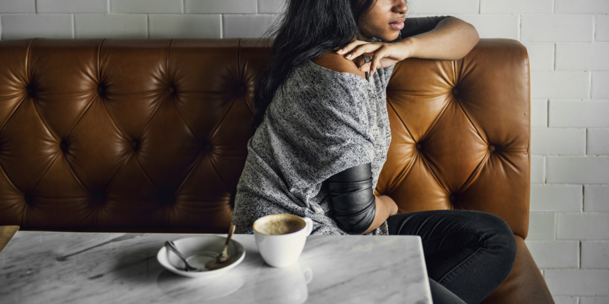 非洲女人喝咖啡店孤独的概念