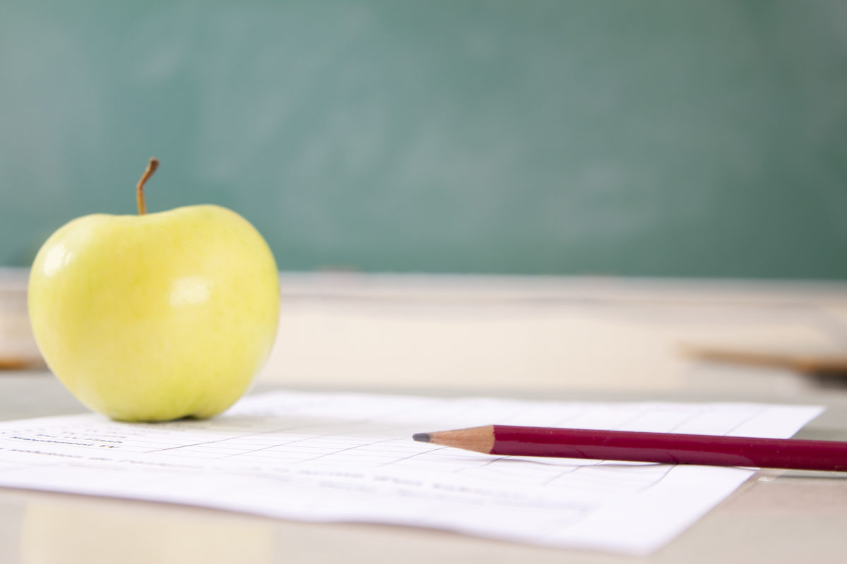 苹果的课堂静物生活，铅笔和家庭作业，以及定制文本的复印空间。