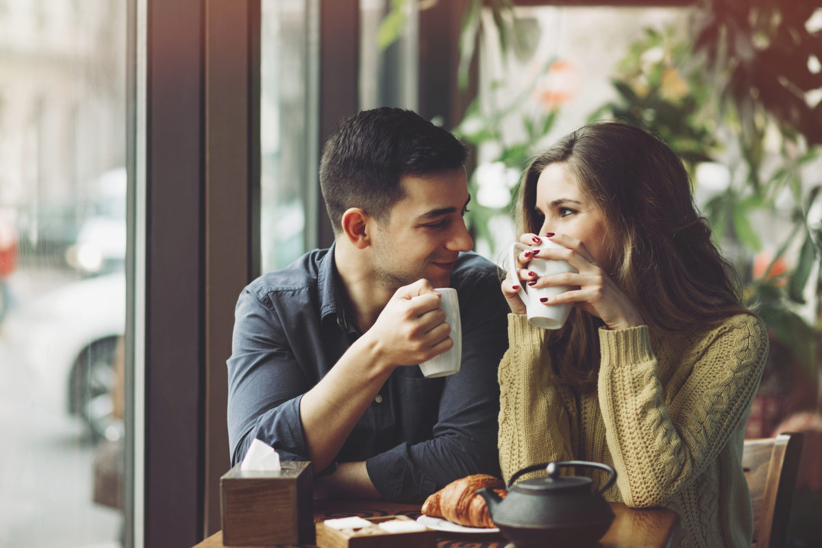情侣们喜欢喝咖啡，在咖啡馆里玩得很开心。爱的概念。复古效果风格图片