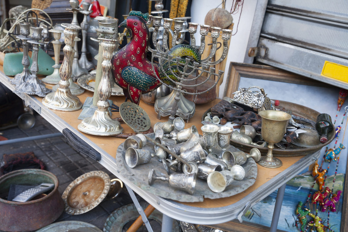 一张桌子上放着基杜什的杯子，烛台，犹太烛台和其他犹太物品在雅法跳蚤市场出售，特拉维夫以色列。