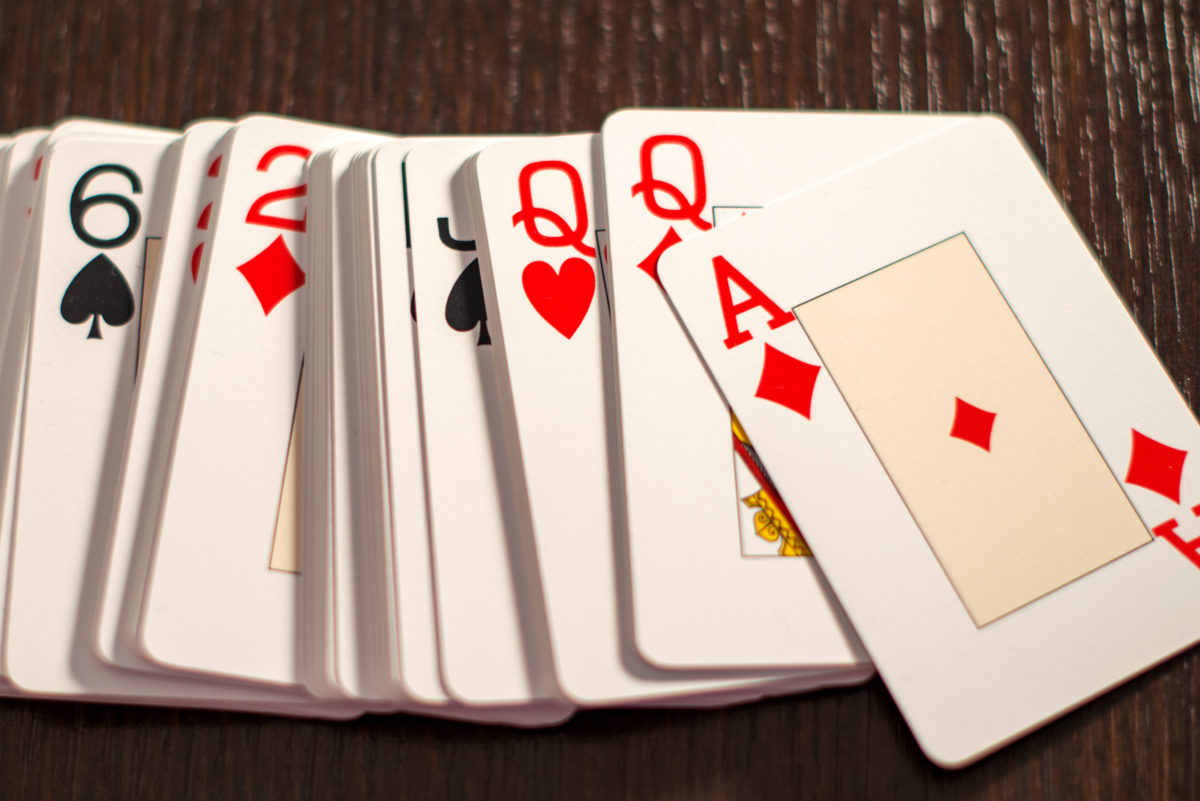 一副扑克牌，在一张木桌上以随机的顺序展开，正面为菱形的a