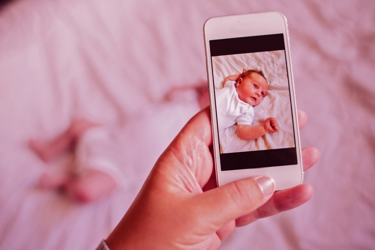 母亲带着她的宝宝的智能手机图片